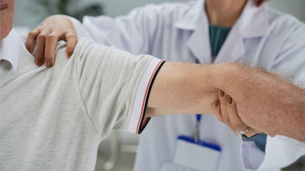 Arthritis Treatment in Kozhikode showing doctor examining shoulder joint pain and mobility