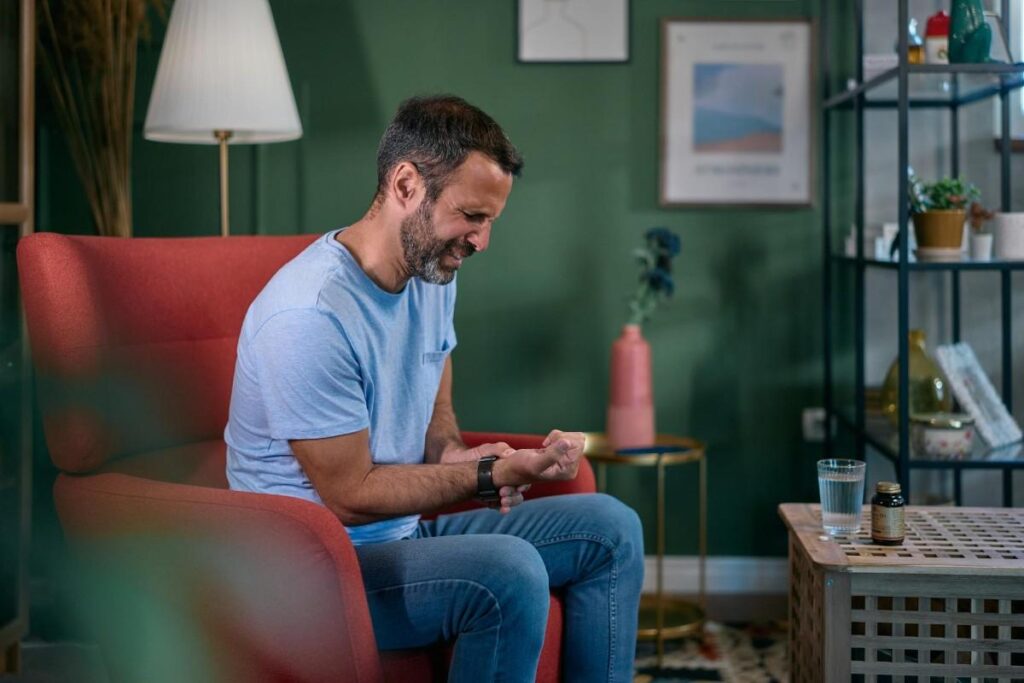 Can Uric Acid Be Controlled Permanently? Person experiencing joint pain while managing uric acid levels and gout symptoms with prescribed medication.